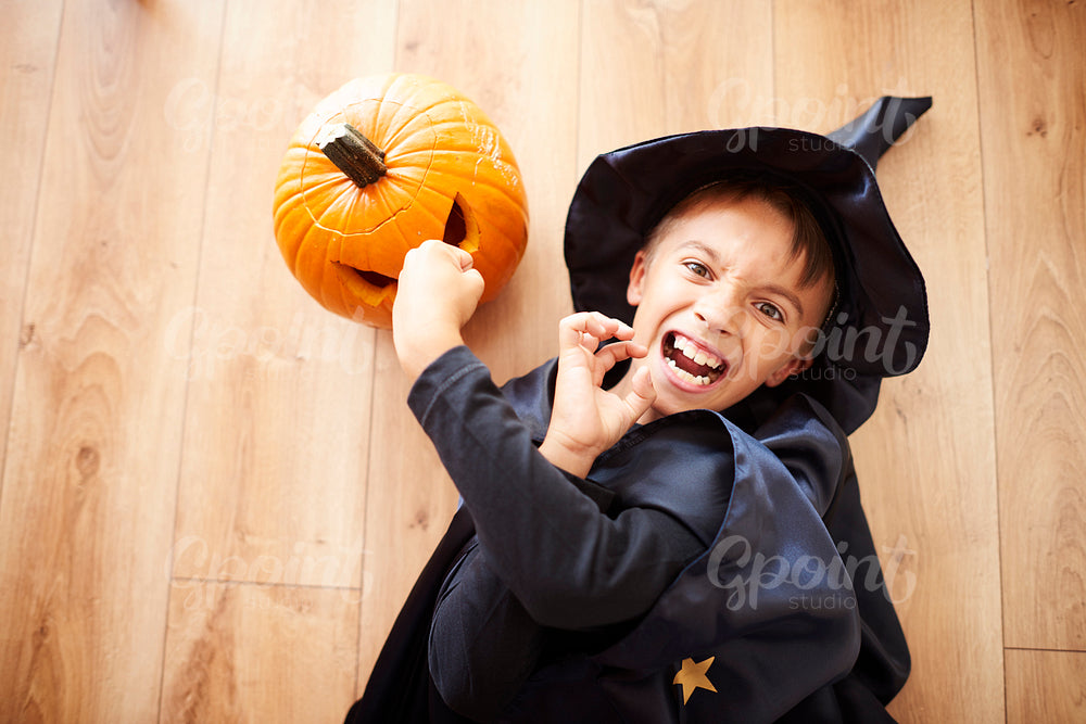 Little wizard on the floor with pumpkin