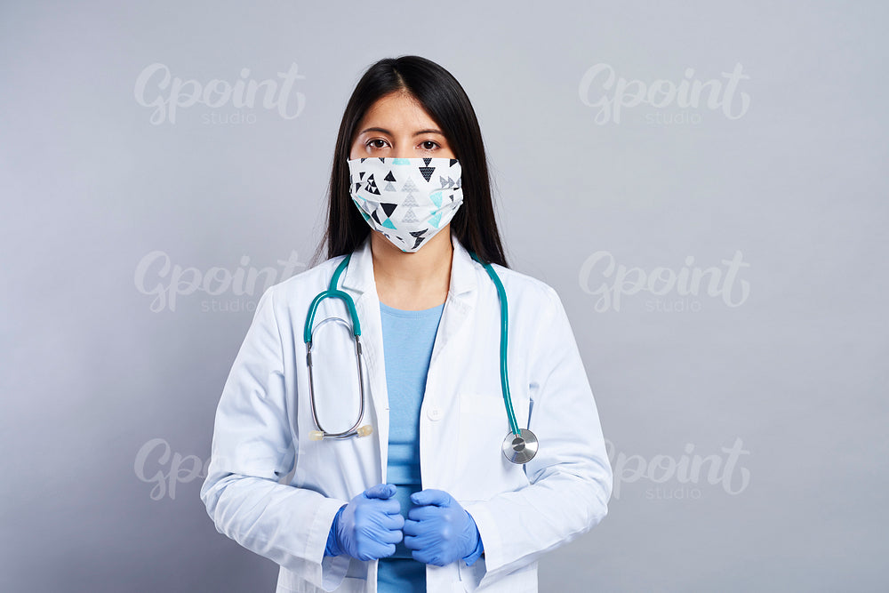 Mid shot portrait of Asian female doctor in face mask