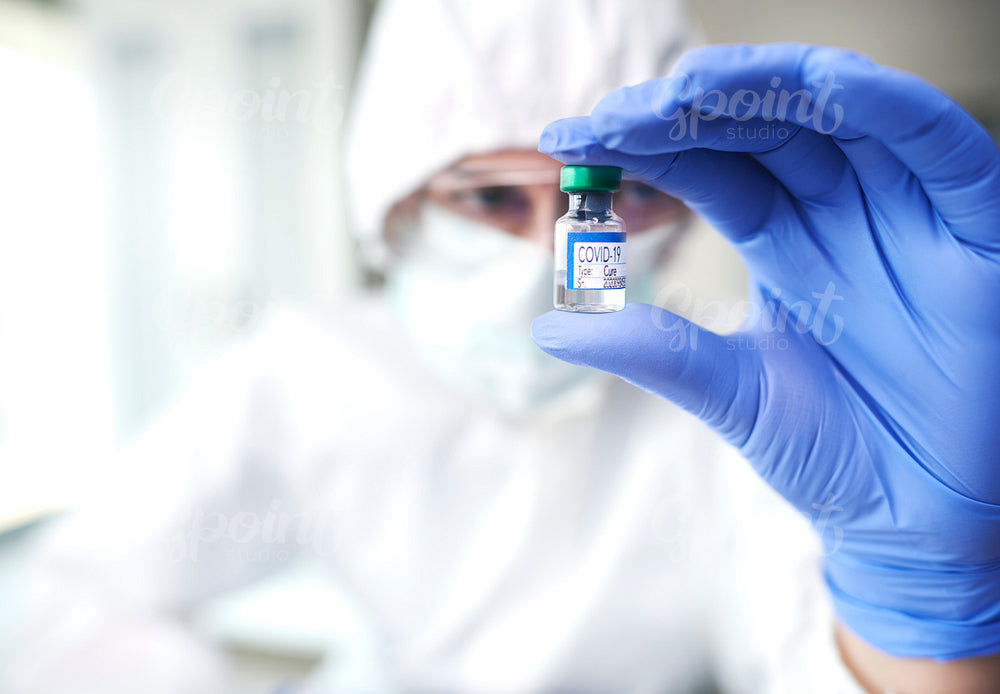Technician holding an ampule with coronavirus cure