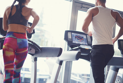 Fit couple exercising on treadmill