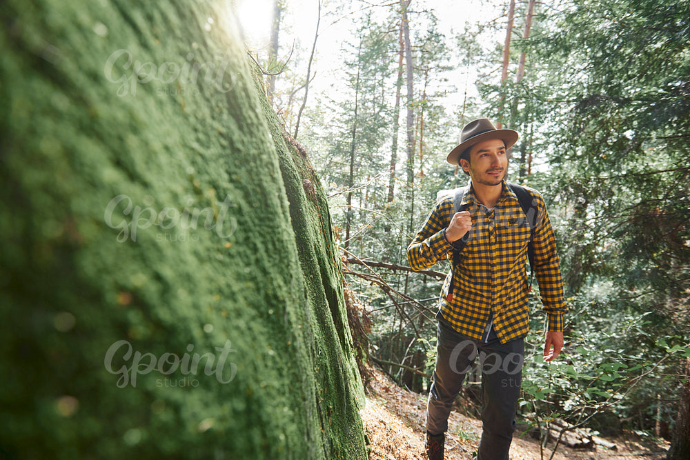 Male hiker with backpack walking through forest