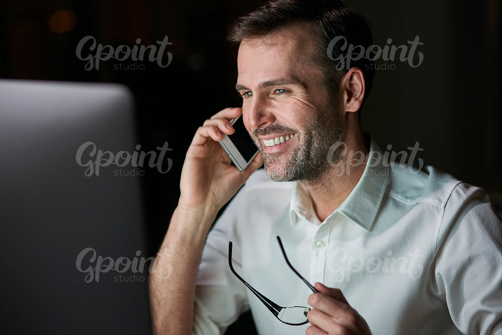 Close up of happy businessman talking by mobile phone