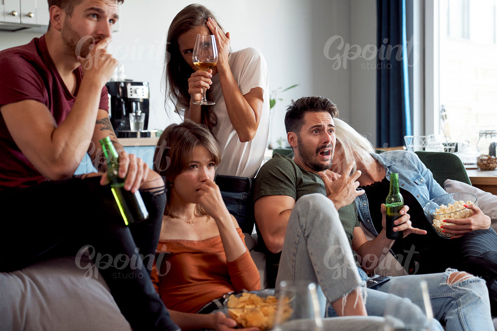 Friends watching horror movie at home