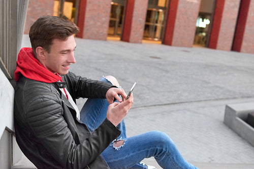 Young man using smart phone outdoors