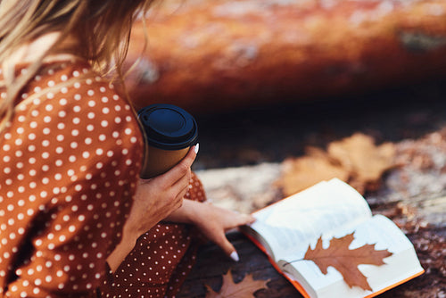 Close up of relaxing with a book and coffee in autumn forest