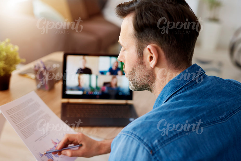 Man analyzing document and having a video conference