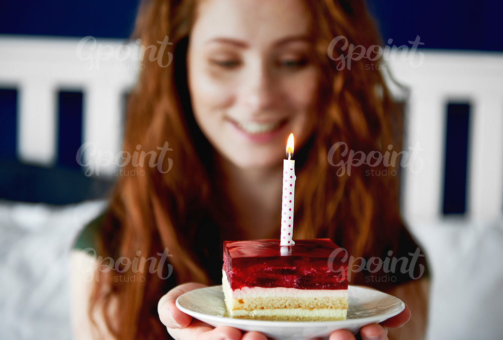 Close up of woman with a piece of birthday cake