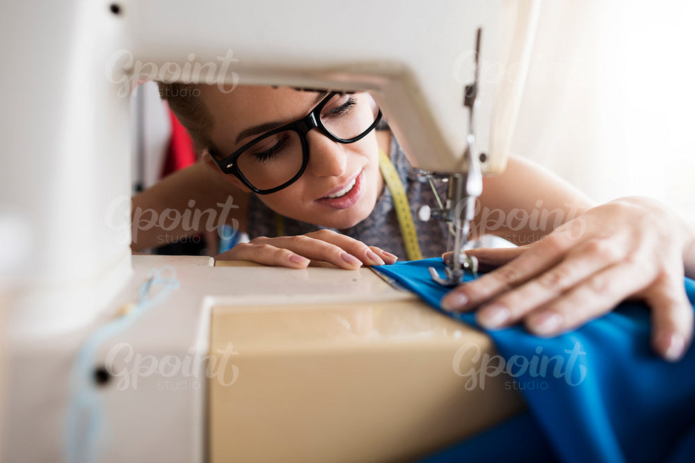 Young tailor working with sewing machine