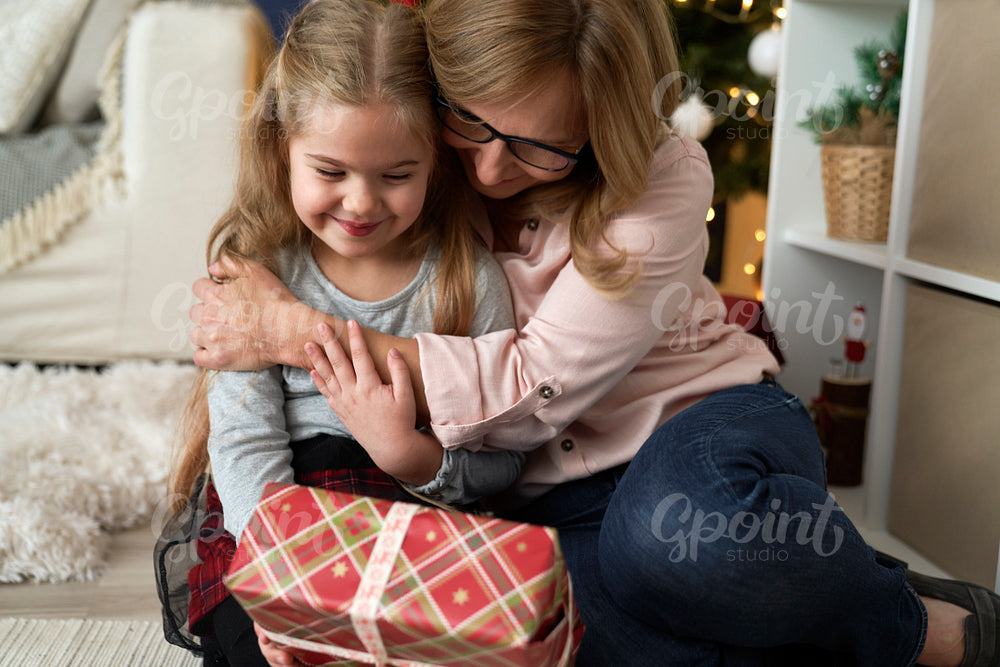 Close up of grandmother giving her granddaughter a Christmas gift