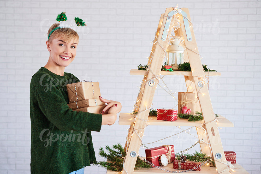 Portrait of girl holding stack of christmas gifts