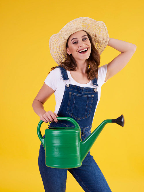 Portrait of female gardener with watering can in studio shot