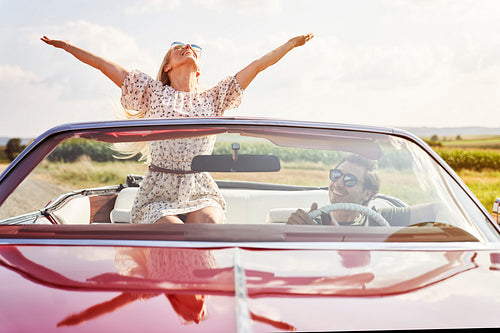 Front view of happy young people in a cabriolet