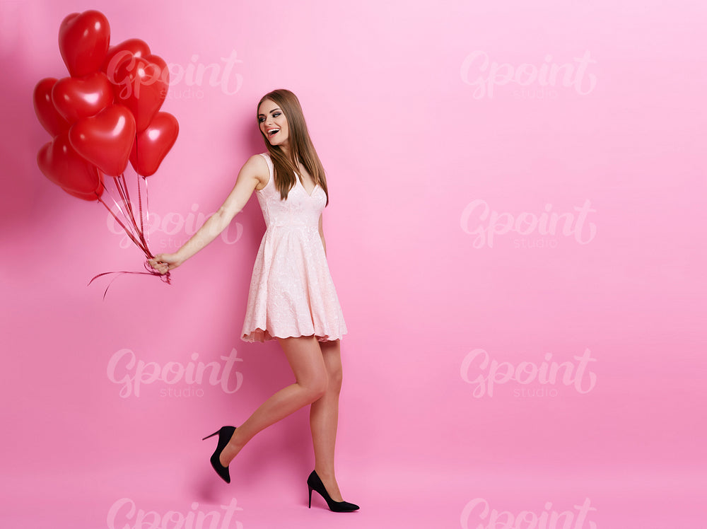 Woman pulling bunch of balloons