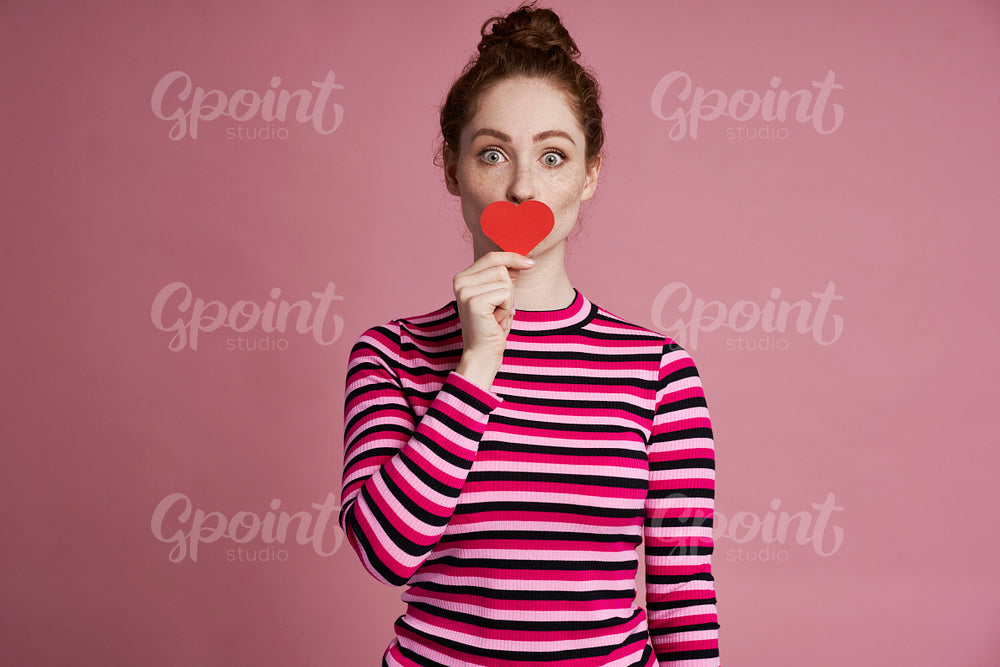 Studio shot of young woman with heart shape on the lips 