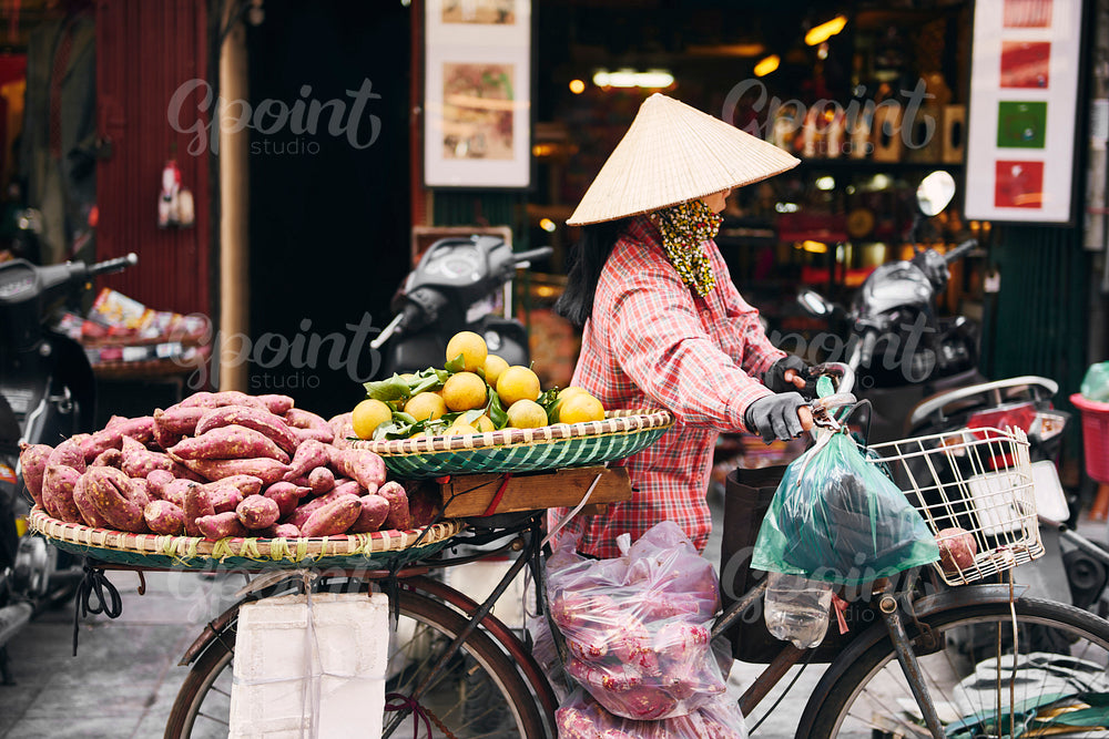 Vietnamese woman with bike selling tropical fruit at the market