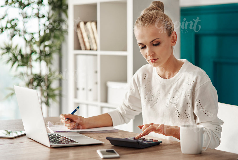 Concentrated woman budgeting at office