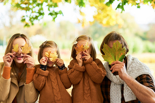 Happy family having fun with autumnal leaves