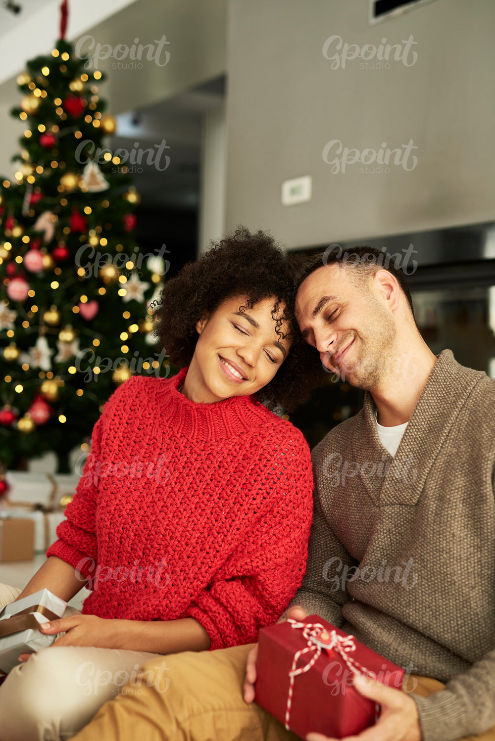 Affectionate couple exchanging Christmas gifts