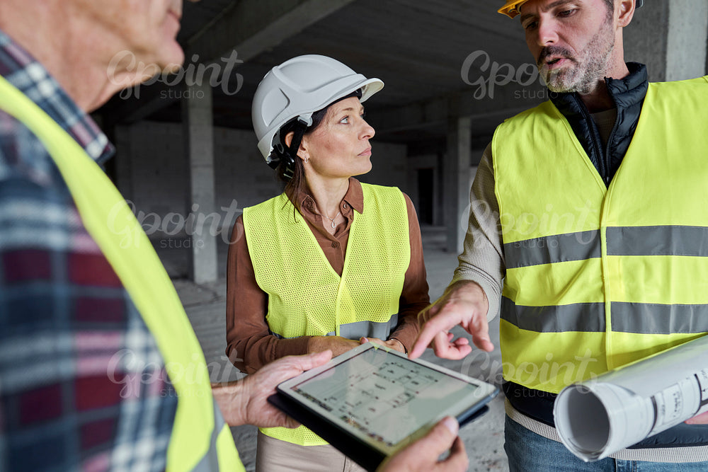 Three caucasian engineers discussing together on the construction site