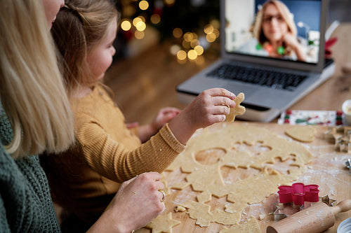 Little girl showing her grandma Christmas cookies during video conference