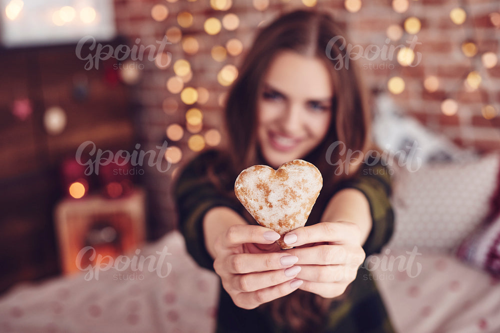 Heart-shaped cookie in human hand