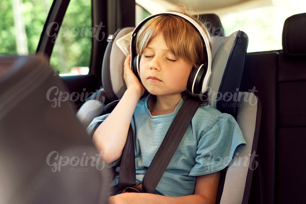 Little girl listening to music while traveling by car