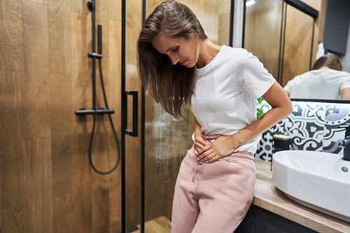 Woman feeling strong stomachache at bathroom