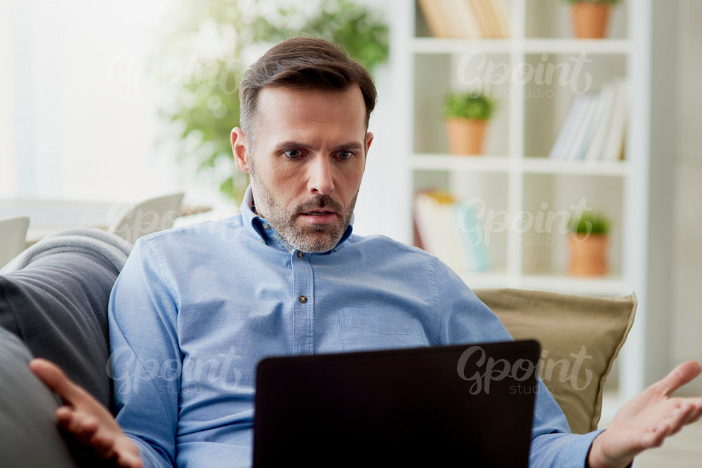 Angry man working home on a computer