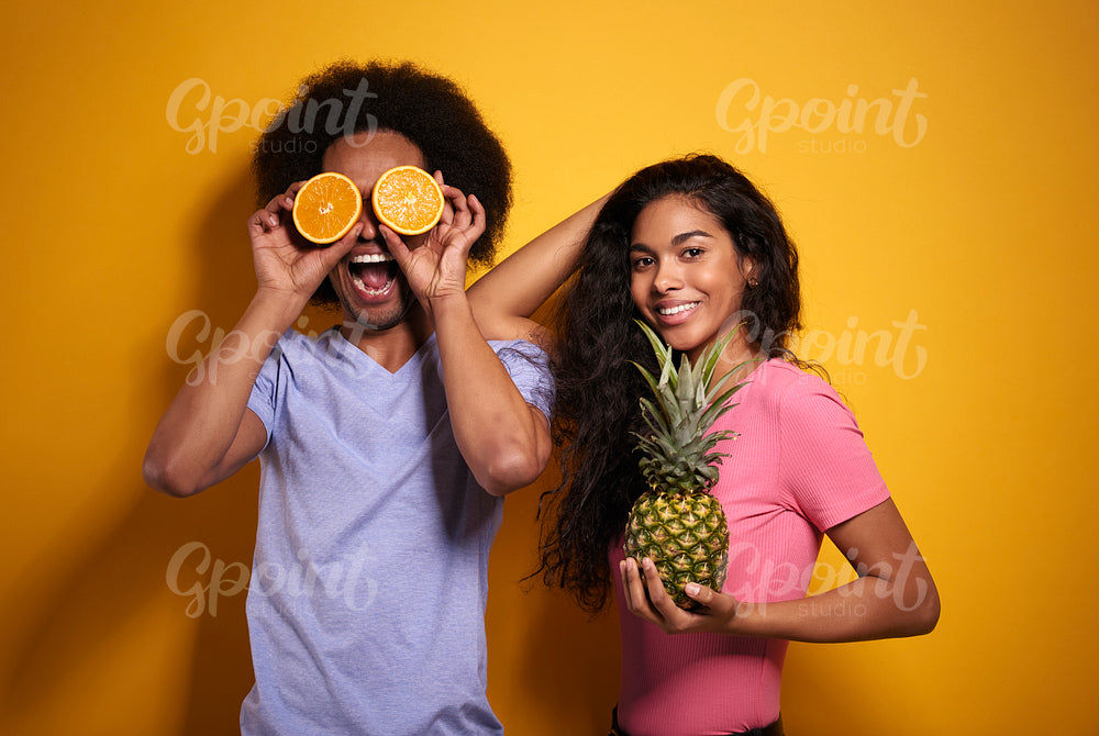 Afroamerican couple cheering with exotic fruits
