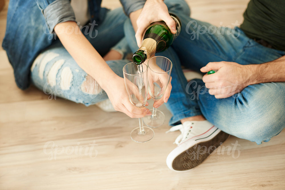 Couple cheering new life with glass of champagne