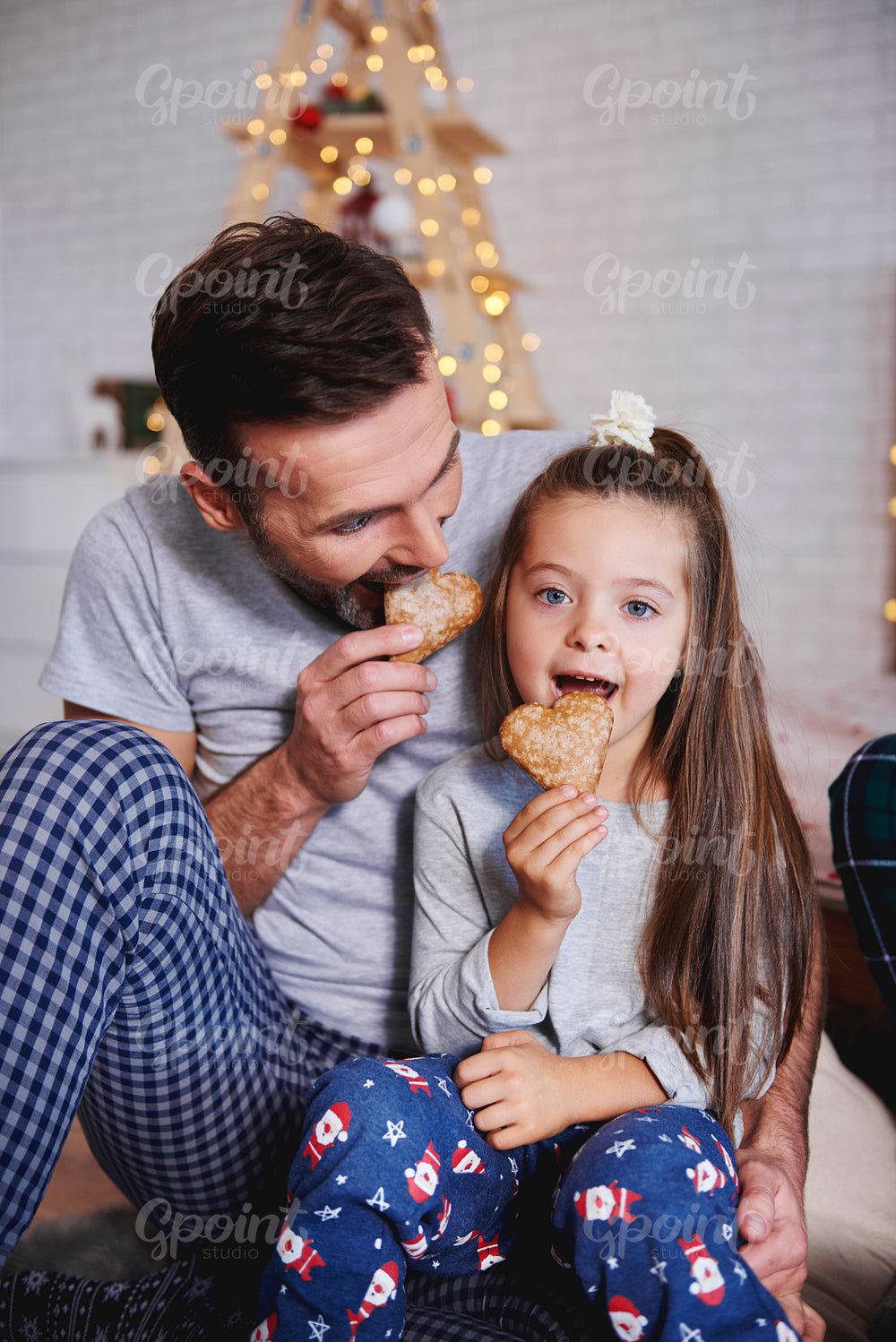 Father and daughter eating gingerbread at christmas
