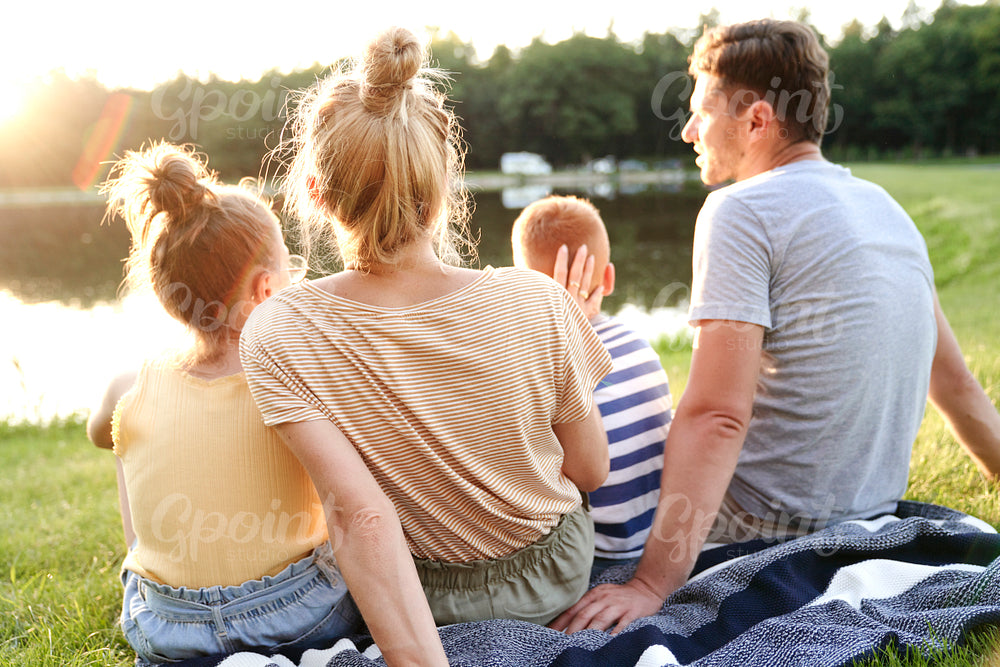 Family watching sunset by the lake