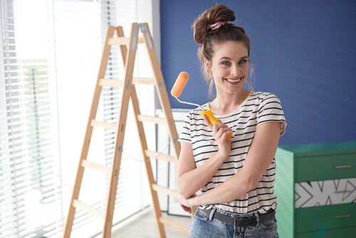 Portrait of ambitious woman with paint roller