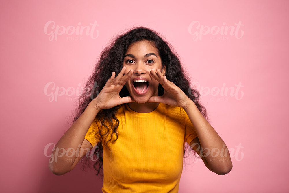 Young African woman screaming loudly in a studio shot.