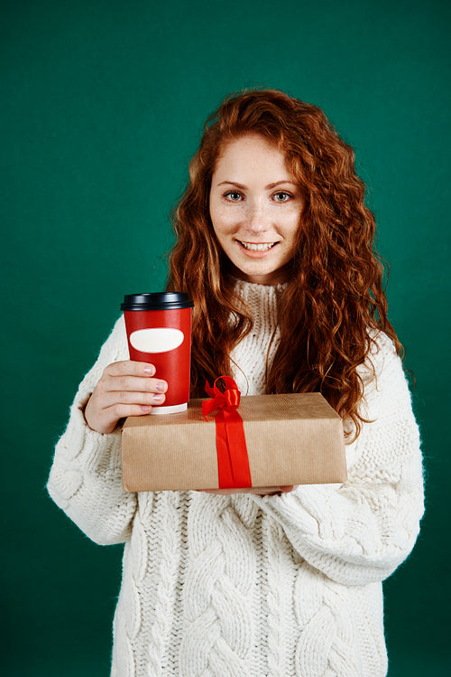 Smiling woman giving gift and coffee