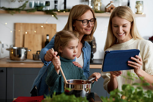 Three generations of women looking for recipe on the tablet