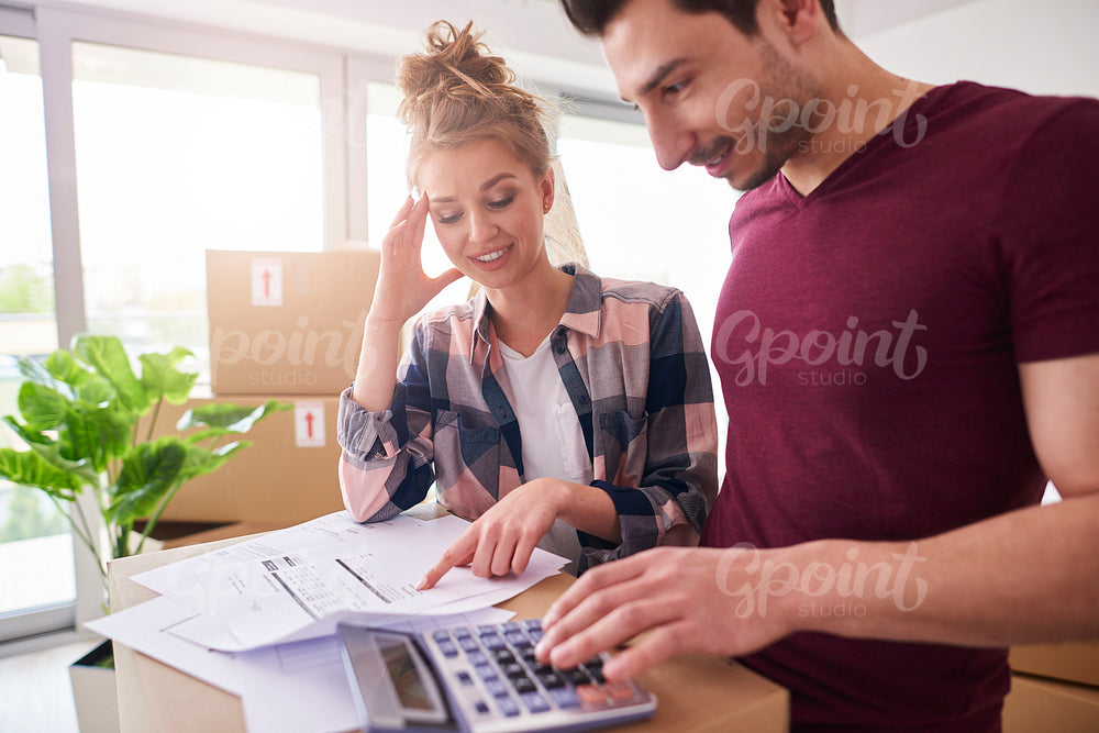 Worried couple examining expenses after moving into new house