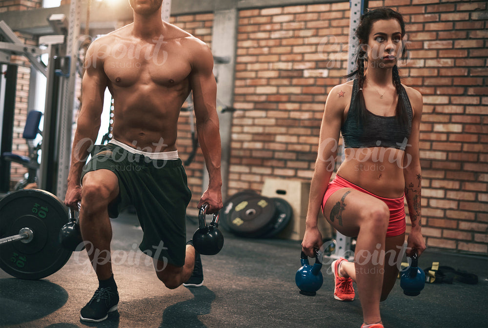 Young couple working out with kettlebells