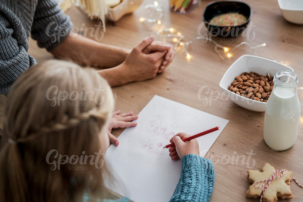 Rear view of girl writing a letter to Santa Claus