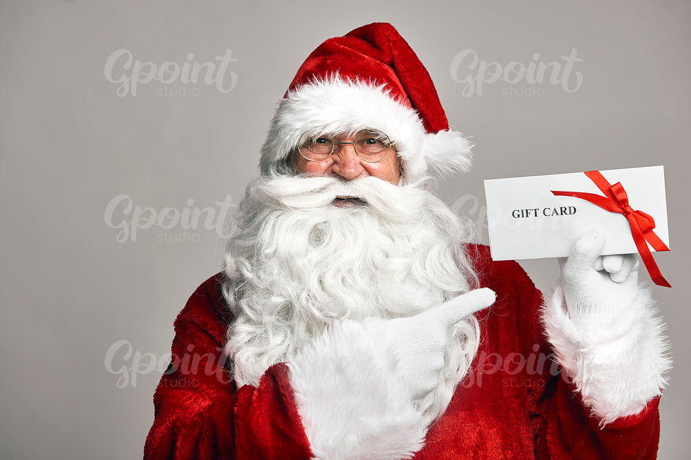 Santa Claus holding gift card in hands