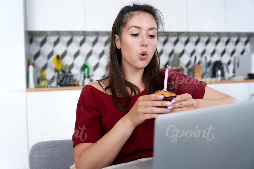 Woman blowing birthday candle in loneliness