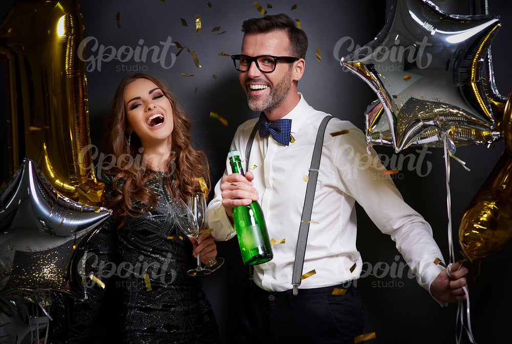 Couple with champagne and glasses laughing