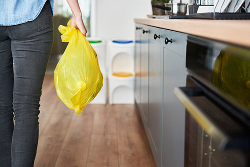 Woman carrying segregated plastic in yellow bag