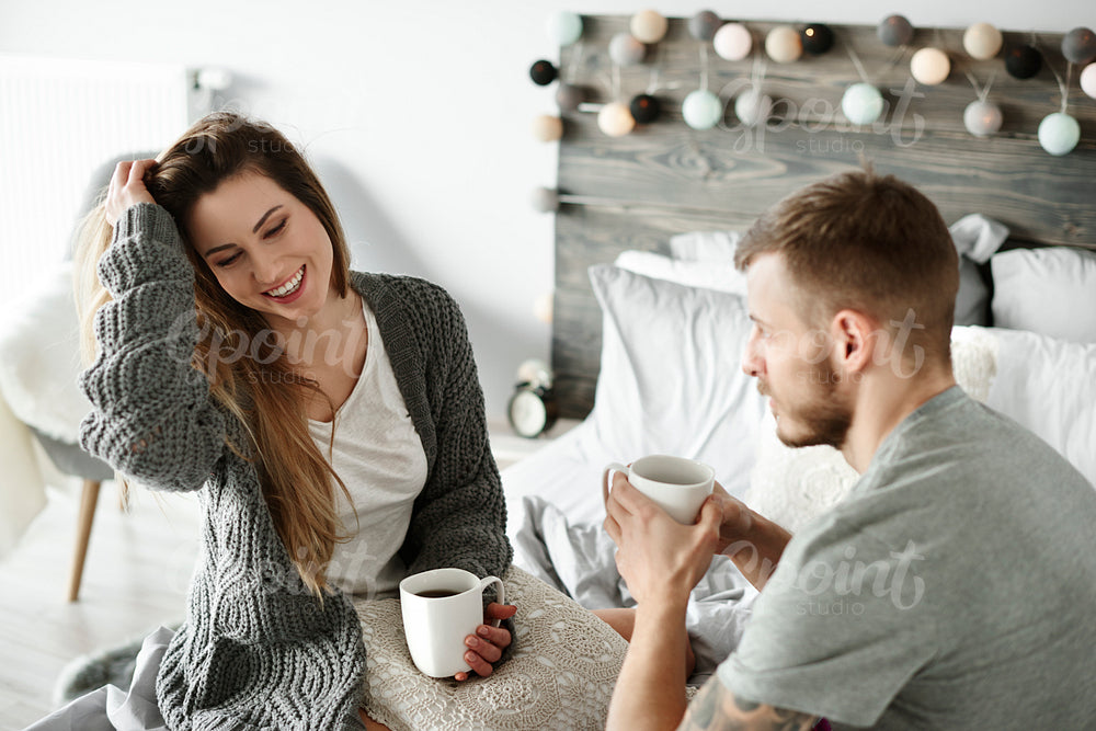 Couple drinking morning coffee at bedroom