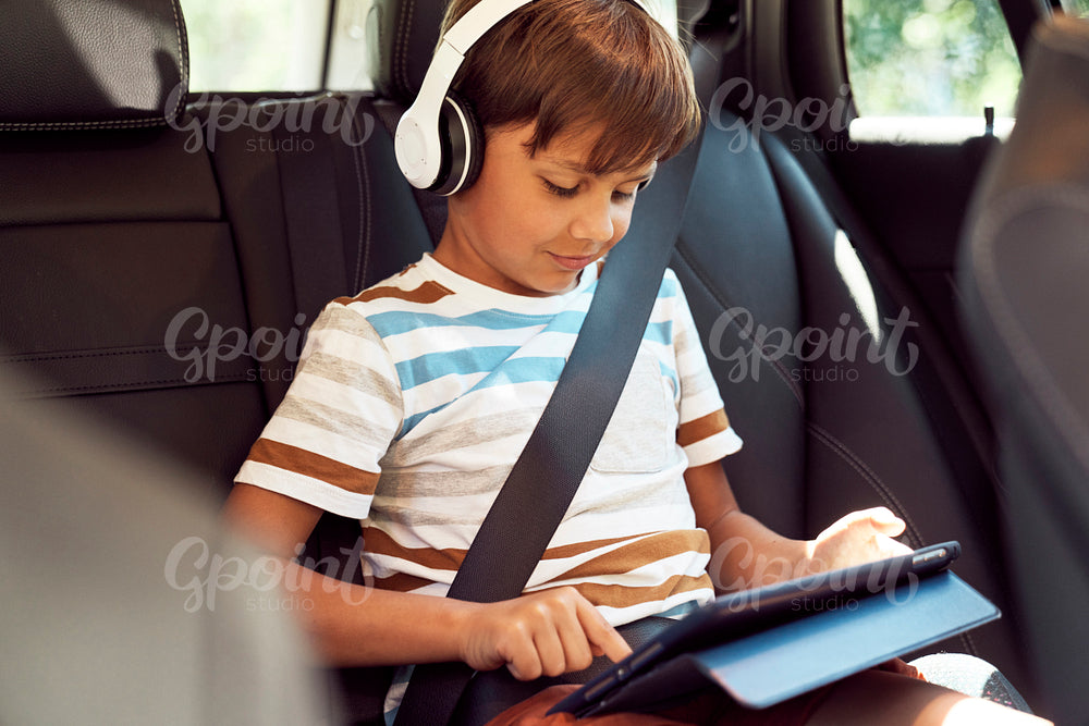 Boy sitting with a digital tablet in the car