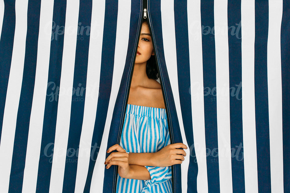 Caucasian woman in striped swimwear looking at camera