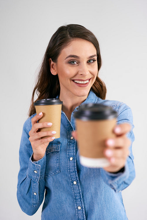 Portrait of smiling woman holding disposable cup of coffee