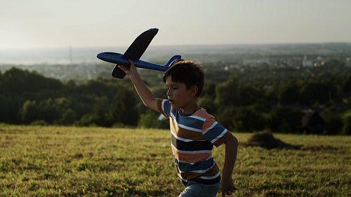 Video of boy running with a plane outdoors