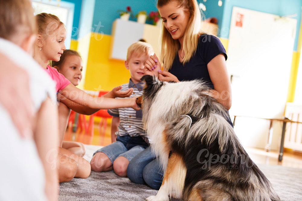 Young woman and her therapy dog working with children