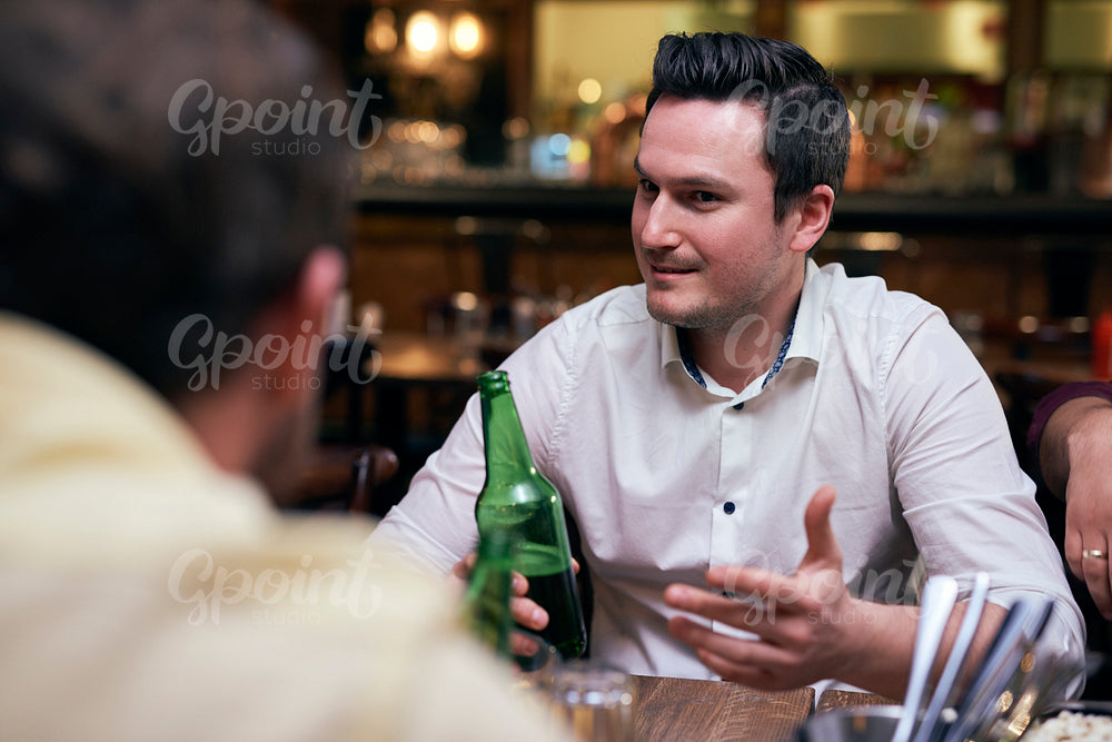 Handsome men drinking beer in the pub